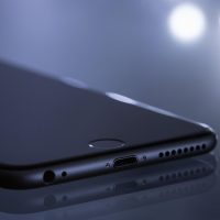 产品负责人何知野在测试手机上检查页面在不同字号下的阅读效果，身旁是贴满流程图的墙面，氛围专注且有条理