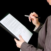 版权专员苏晚青在办公室审阅投诉邮件与权属材料，桌面上放着标注过的文件与印章，画面透出严谨细致的合规工作氛围